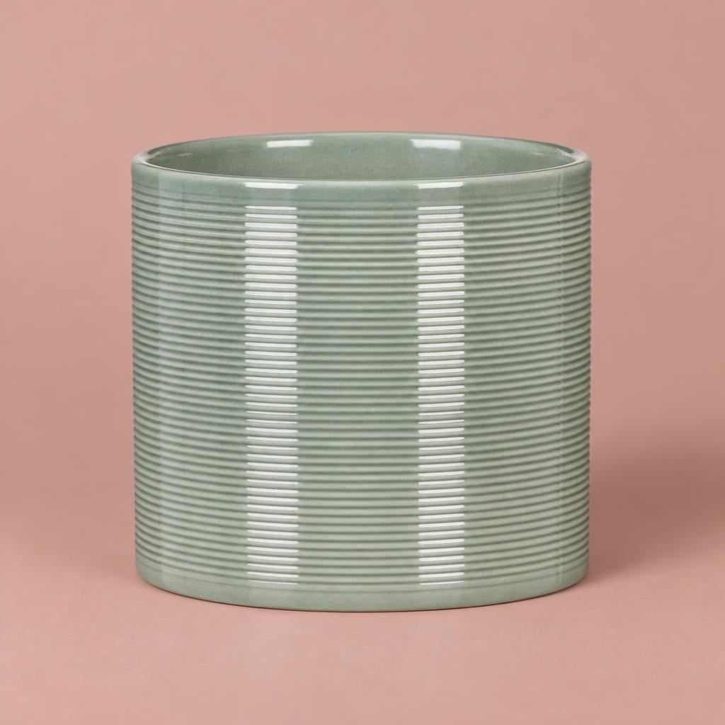 Sage green ceramic pot with fine horizontal ribbing and a glossy finish