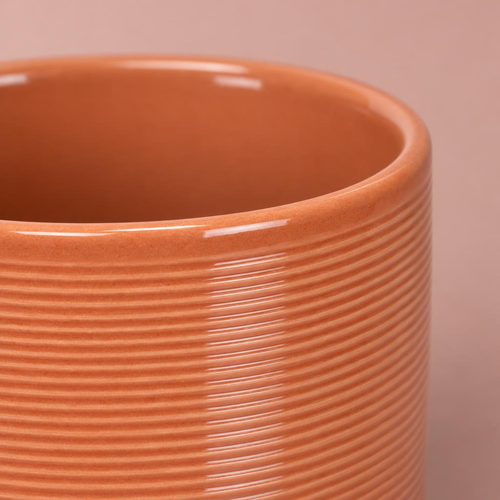 Papaya coral-orange ceramic pot with a glossy finish and fine ribbed detail