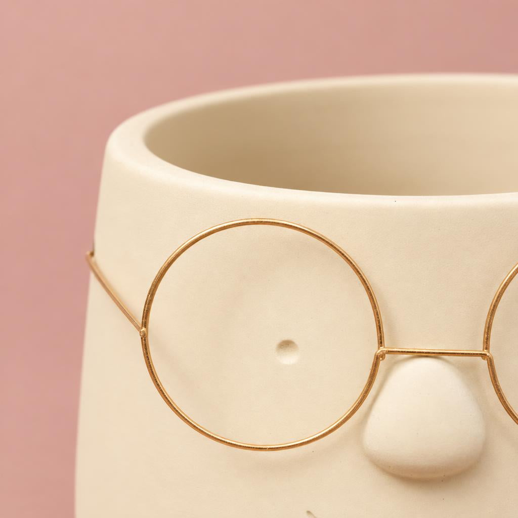 Happy gold plant pot with a minimalist glasses design